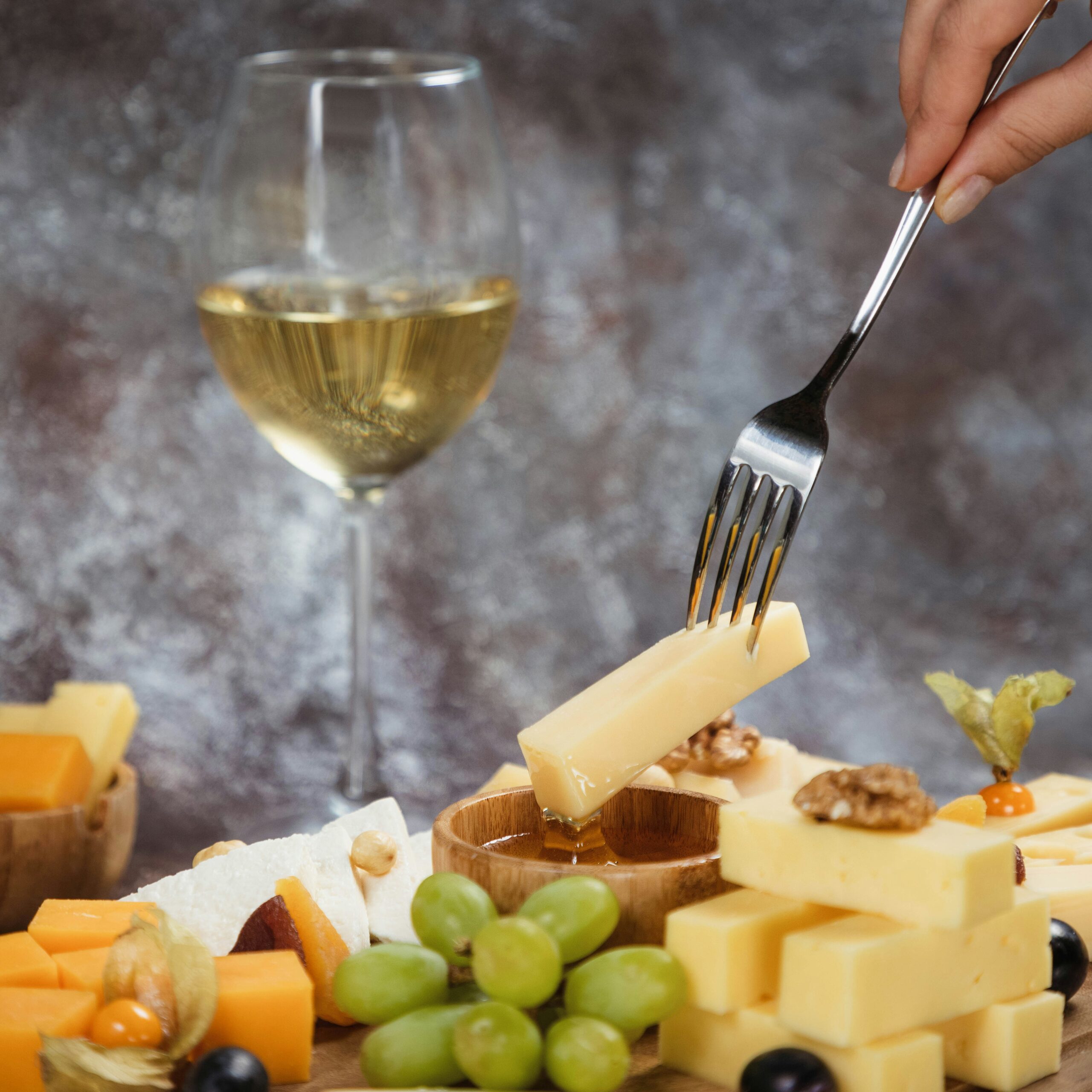 Artisan cheese board with white wine and honey
